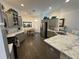 Open-concept kitchen featuring gray cabinets, marble countertops and stainless steel appliances at 862 Bowden Rd, The Villages, FL 32163