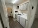 Well-equipped laundry room with washer, dryer, built-in cabinets and gray trim at 862 Bowden Rd, The Villages, FL 32163