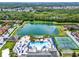 Beautiful community aerial view featuring a lake, clubhouse, pool, and tennis courts at 8977 Majesty Palm Rd, Kissimmee, FL 34747