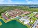 Wide aerial view of community featuring pool, tennis courts, lake, and vibrant landscaping at 8977 Majesty Palm Rd, Kissimmee, FL 34747