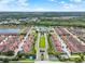 Wide aerial view of the community featuring colorful townhomes, lush greenery, and serene lake at 8977 Majesty Palm Rd, Kissimmee, FL 34747