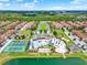 Picturesque community aerial view featuring pool, clubhouse, tennis courts, and lake at 8977 Majesty Palm Rd, Kissimmee, FL 34747
