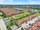 High aerial view of the community with colorful townhomes, lush landscaping, and a peaceful lake setting at 8977 Majesty Palm Rd, Kissimmee, FL 34747
