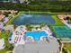 Stunning aerial view of community amenities, including lake, pool, clubhouse and tennis courts at 8977 Majesty Palm Rd, Kissimmee, FL 34747