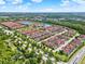 Expansive aerial view of the community featuring colorful townhomes, lush greenery, and tranquil lakes at 8977 Majesty Palm Rd, Kissimmee, FL 34747