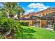 Well-manicured backyard with a screen-enclosed patio and lush green lawn at 8977 Majesty Palm Rd, Kissimmee, FL 34747