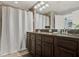 Bathroom featuring dual sink vanity, large mirror, tiled floor and shower at 8977 Majesty Palm Rd, Kissimmee, FL 34747