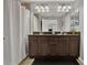 Bathroom featuring dual sink vanity, large mirror, tiled floor and shower at 8977 Majesty Palm Rd, Kissimmee, FL 34747