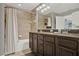 Bathroom featuring dual sink vanity, large mirror, tiled floor and shower at 8977 Majesty Palm Rd, Kissimmee, FL 34747