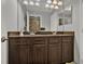 Spacious bathroom vanity with dual sinks and large mirror, tiled shower in background at 8977 Majesty Palm Rd, Kissimmee, FL 34747
