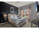 Comfortable bedroom features a black accent wall and a plush bed with fresh linens at 8977 Majesty Palm Rd, Kissimmee, FL 34747