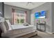 This bedroom features a flat screen television and a large bright window at 8977 Majesty Palm Rd, Kissimmee, FL 34747