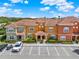 Beautiful exterior view of townhomes with vibrant colors, manicured landscaping, and reserved parking spaces at 8977 Majesty Palm Rd, Kissimmee, FL 34747
