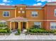 Inviting townhouse with a red tile roof and well-maintained landscaping at 8977 Majesty Palm Rd, Kissimmee, FL 34747
