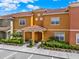 Inviting townhouse with a red tile roof and well-maintained landscaping at 8977 Majesty Palm Rd, Kissimmee, FL 34747