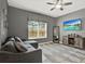 Comfortable living room featuring a sectional sofa, modern decor, and entertainment center with wall mounted TV at 8977 Majesty Palm Rd, Kissimmee, FL 34747