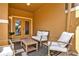 Cozy covered patio featuring neutral furnishings, a coffee table, and a door leading to the interior at 8977 Majesty Palm Rd, Kissimmee, FL 34747