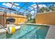 Inviting screened-in pool area with clear blue water and outdoor grill, perfect for entertaining at 8977 Majesty Palm Rd, Kissimmee, FL 34747