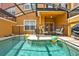 Refreshing pool with safety fence in screened-in lanai, complemented by a cozy patio setup at 8977 Majesty Palm Rd, Kissimmee, FL 34747