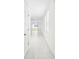 Bright hallway with neutral tile flooring leading to an open-concept living area and sliding glass doors at 903 Donahue Pass, Lake Hamilton, FL 33851