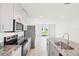 Contemporary kitchen with stainless steel appliances, granite countertops, and an open view to the living area at 903 Donahue Pass, Lake Hamilton, FL 33851