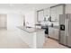 Modern kitchen with gray cabinets, stainless steel appliances, granite countertops, and a large island at 903 Donahue Pass, Lake Hamilton, FL 33851