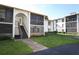 Condo complex with a landscaped lawn with covered screened in patios at 954 Courtyard Ln # 52, Orlando, FL 32825