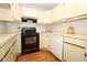 Kitchen featuring cream-colored cabinets, black appliances, and modern fixtures at 954 Courtyard Ln # 52, Orlando, FL 32825