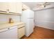 Kitchen with white cabinets and appliances, complemented by wood-look flooring at 954 Courtyard Ln # 52, Orlando, FL 32825