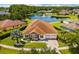 Aerial view of house with lush lawn and a large pond with fountain behind the house at 9821 Caroline Park Dr, Orlando, FL 32832