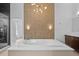 Luxurious bathroom with a large tub, decorative lighting, and vanity at 9821 Caroline Park Dr, Orlando, FL 32832