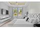 This bedroom features a tray ceiling, chandelier, and plenty of natural light from the double window at 9821 Caroline Park Dr, Orlando, FL 32832