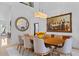 Dining room with modern table, white walls, large painting, and neutral colors at 9821 Caroline Park Dr, Orlando, FL 32832
