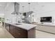Modern kitchen with island, stainless steel hood, and open concept living space at 9821 Caroline Park Dr, Orlando, FL 32832