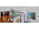 Open staircase with hardwood floors, glass railing, and modern decor at 9821 Caroline Park Dr, Orlando, FL 32832