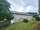 Back exterior view of house showing manicured lawn and trees at 13157 Paloma Dr, Orlando, FL 32837