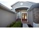 Inviting front entrance features elegant double doors, decorative stone accents, and a cozy bench at 13157 Paloma Dr, Orlando, FL 32837