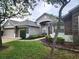 Charming single-story home showcasing stone accents, manicured garden beds, and a two-car garage at 13157 Paloma Dr, Orlando, FL 32837