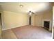 A carpeted living room featuring a fireplace and a ceiling fan at 13157 Paloma Dr, Orlando, FL 32837