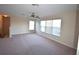 Spacious living room featuring neutral carpet, staircase, and natural light from multiple windows at 13157 Paloma Dr, Orlando, FL 32837