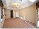 Large primary bedroom featuring tray ceiling, fan, and a hallway that leads to primary bath at 13157 Paloma Dr, Orlando, FL 32837