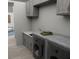 Well-equipped laundry room with gray cabinets, modern washer and dryer, and sleek countertops at Tbd Sw 177Th St, Ocala, FL 34473