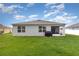 Lush backyard featuring well-maintained lawn, enclosed patio, and a covered grill at 1010 Morvan Ln, Kissimmee, FL 34759