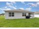 Grassy backyard featuring well-maintained lawn and covered grill at 1010 Morvan Ln, Kissimmee, FL 34759