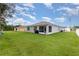 Expansive backyard featuring well-maintained lawn, neighboring properties, and screened patio at 1010 Morvan Ln, Kissimmee, FL 34759