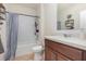 Bathroom featuring tile floors, wooden cabinets, shower and modern fixtures at 1010 Morvan Ln, Kissimmee, FL 34759