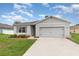 Charming single-story home with a two-car garage, a well-manicured lawn, and gray shutters at 1010 Morvan Ln, Kissimmee, FL 34759