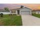 Charming single-story home at dusk featuring a well-maintained lawn, two car garage and neutral color palette at 1010 Morvan Ln, Kissimmee, FL 34759