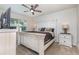 This main bedroom features an expansive bed, carpet floors, ceiling fan and television at 1010 Morvan Ln, Kissimmee, FL 34759