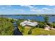A stunning aerial view showcases the waterfront home with lush landscaping and private canal access to the large lake at 10300 Pocket Ln, Orlando, FL 32836